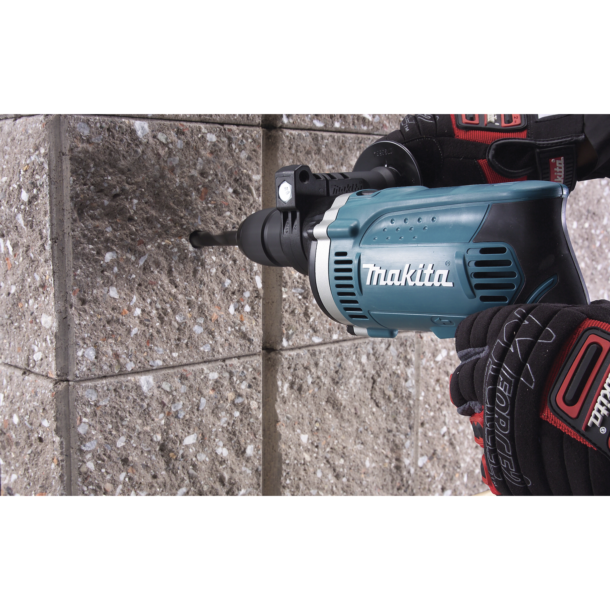 Person bohrt mit Makita Schlagbohrmaschine in eine Wand.